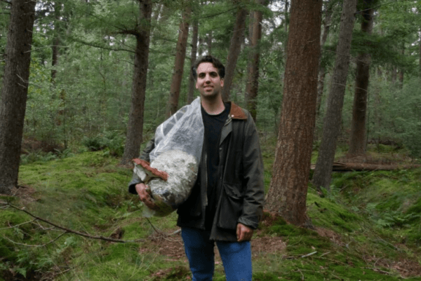 Persoon in bos met zak van Loop