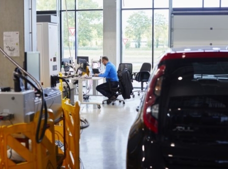 persoon op stoel in achtergrond auto in voorgrond