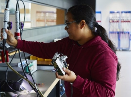 persoon met apparaat in hand naast ander apparaat